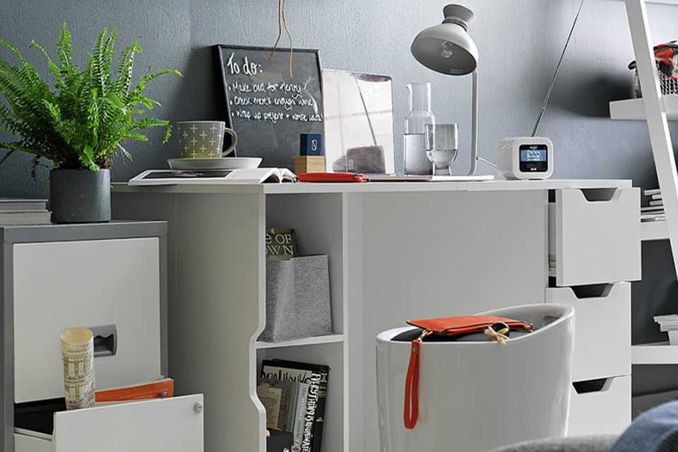 Pierre Henry 2 drawer metal filing cabinet in silver and white placed in a home office next to a white desk.