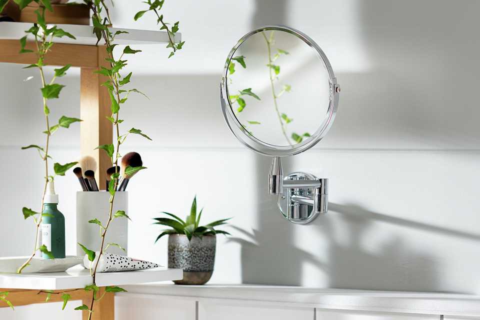 An Argos Home chrome extending round shaving mirror in a bathroom.