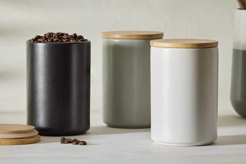 A set of 3 Habitat matte finish ceramic storage canisters in black, grey, and white.
