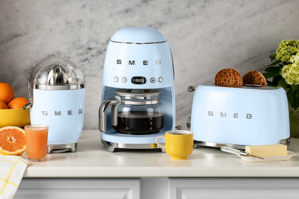 Blue Smeg citrus juicer, drip coffee machine and toaster.