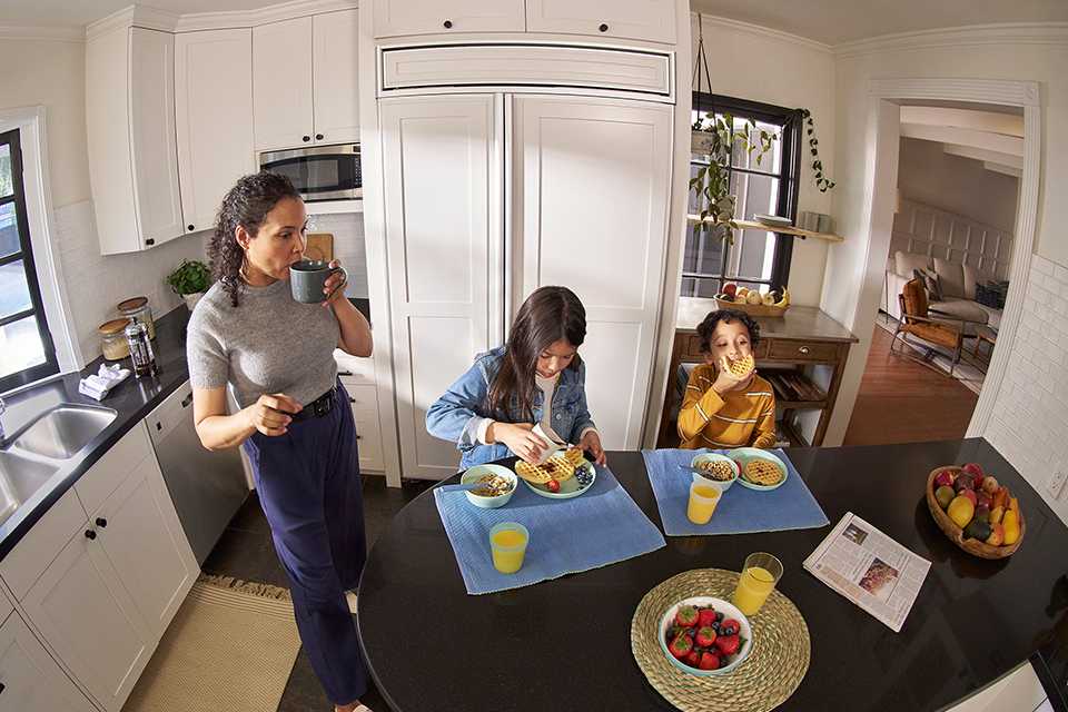 A family of three viewed through a Ring security camera.