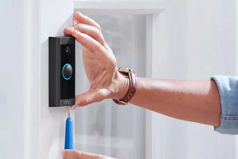 Someone installing a Ring video doorbell.