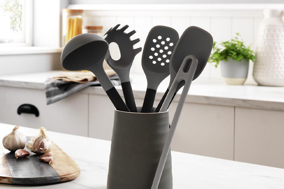 Utensils in a pot on the kitchen side.