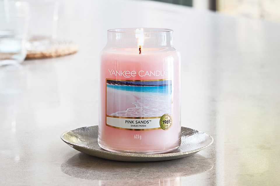 Pink Sands Yankee® jar candle in large size placed on a table top.
