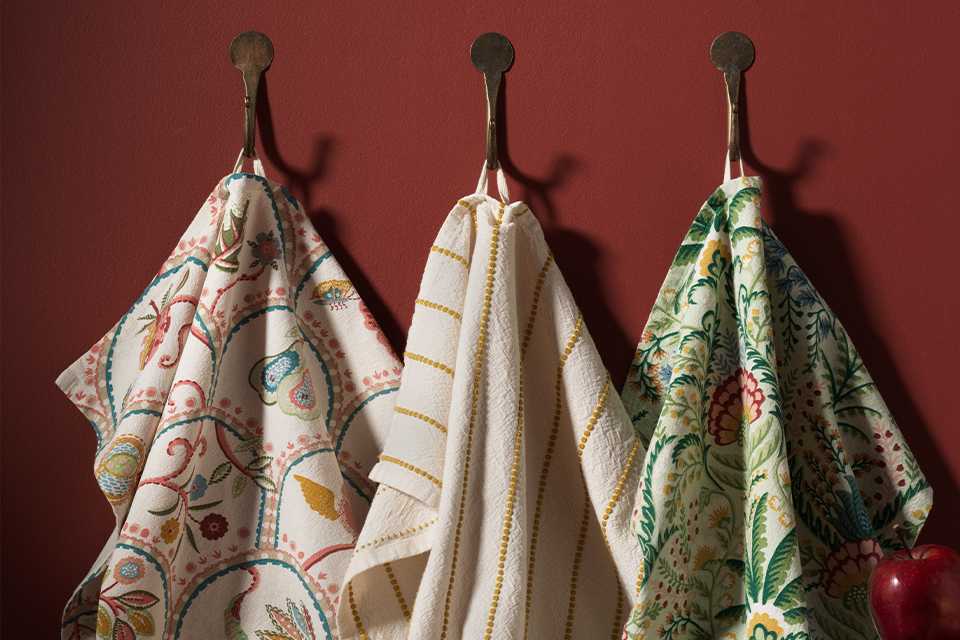 3 pack of tea towels two floral printed and one white and yellow thi stripes.