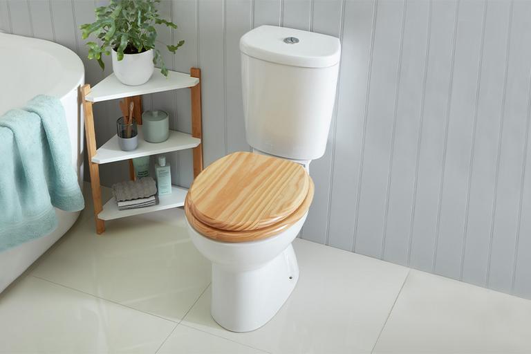 A wooden toilet seat in a bathroom scene.