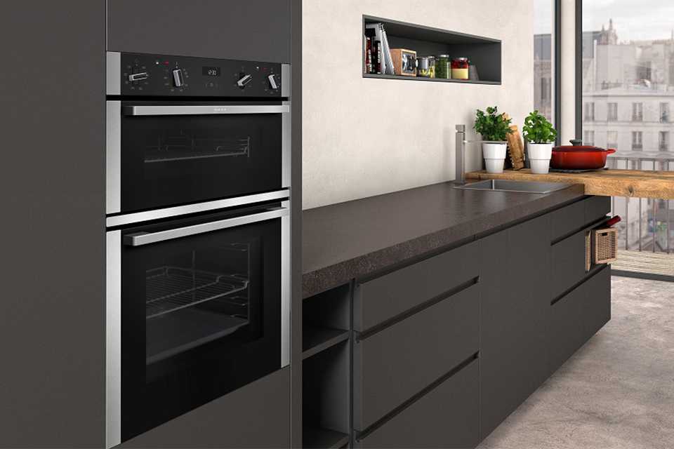 NEFF double ovens mounted inside a grey kitchen wall.