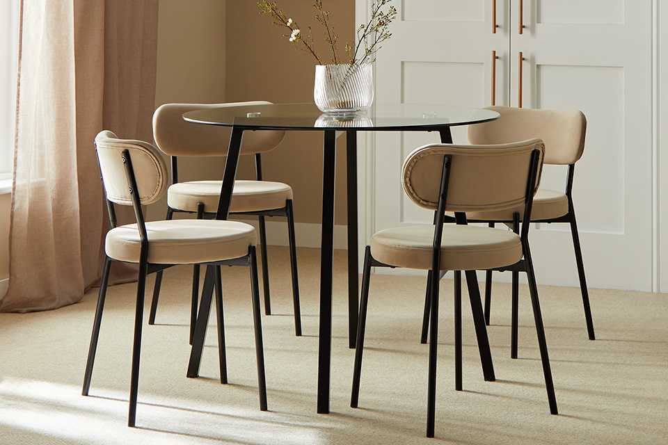 An Argos Home Fyra glass dining table with 4 natural chairs.