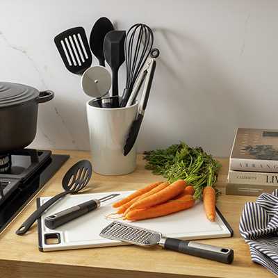 A holder with spatulas and a whisk on a kitchen counter.