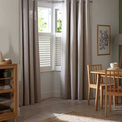 Grey curtains on a window in a living room.