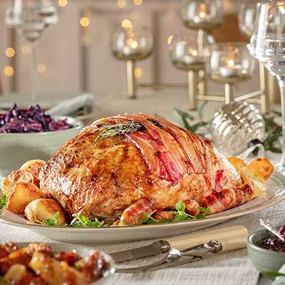 A table set for Christmas dinner with plates, glasses, and food.