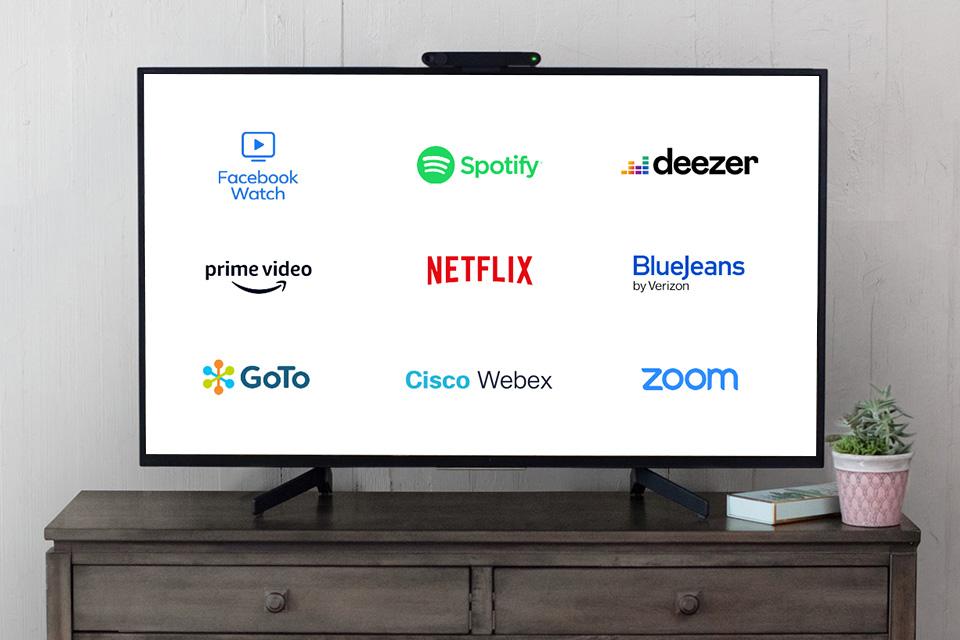 The logos for various apps, including Facebook Watch, Netflix and Spotify, are displayed on a large screen.