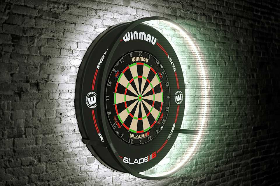 A Winmau Darts Plasma Dartboard Light hanging on a brick wall.