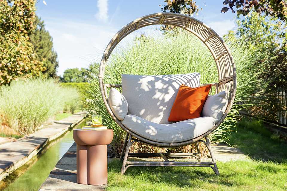 A Habitat Selene natural rattan effect garden egg chair.