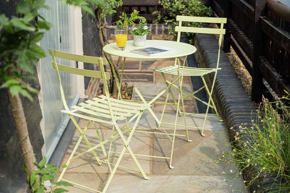 Small outdoor bistro dining set in a garden.