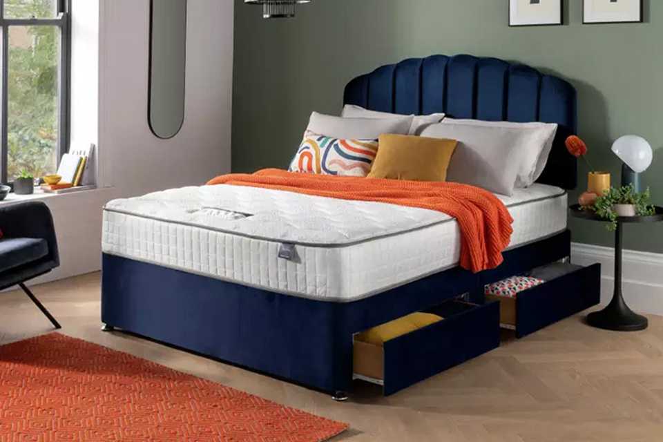 A blue Silentnight storage divan bed in a bedroom setup.