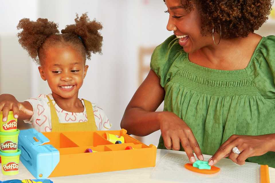 A mother and daughter playing with a Play-Doh Rainbow Animal Storage set with 8 tubs.