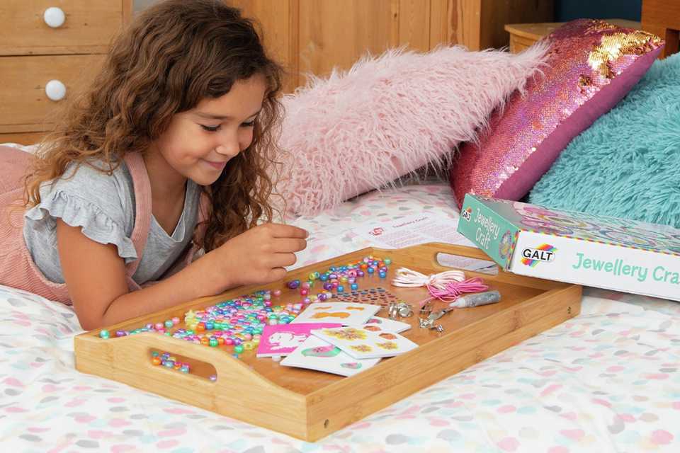 A girl playing with a Galt Jewellery Craft Kit.