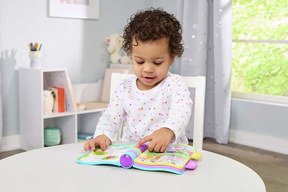 A girl playing with Vtech Peppa Pig Nursery Rhymes book.