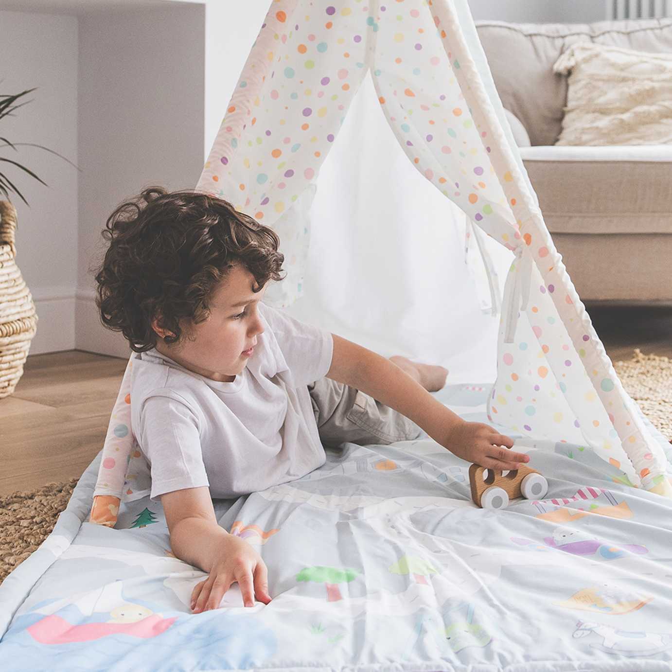 A baby on a playmat with a cover.