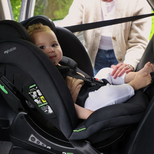 baby sat in My Babiie MBCS100 i-Size 2-in-1 Car Seat - Black in a car