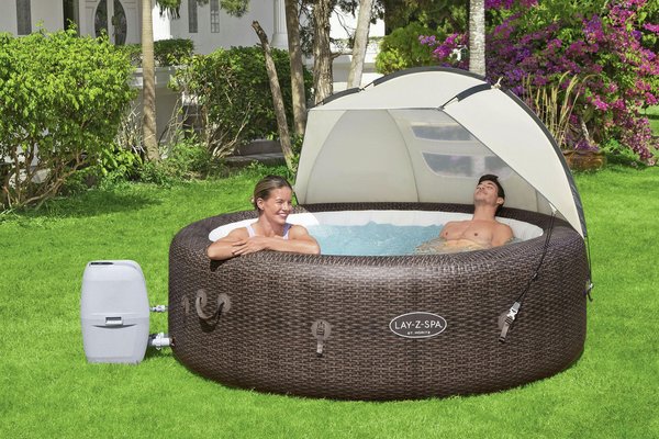 A couple relaxing in a hot tub with Lay-Z-Spa Detachable Hot Tub Canopy over it.