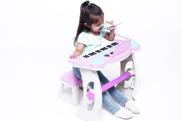 A girl playing a toy keyboard.