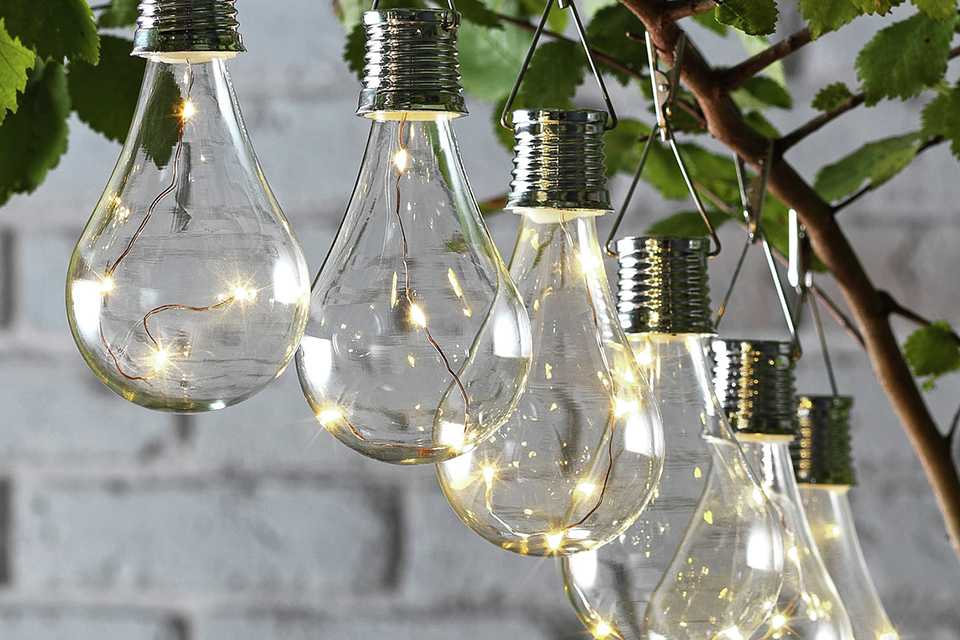Solar lights strung on a tree in a garden.