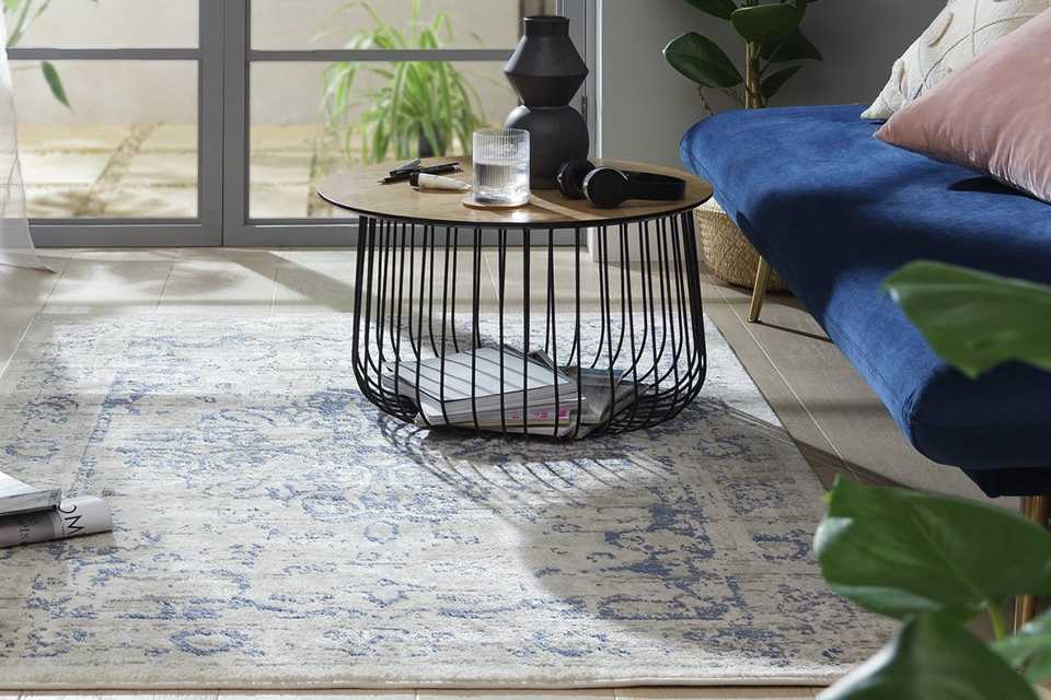 A living room setup with Habitat Traditional Natural & Blue Cut Pile Rug, a coffee table and a sofa.