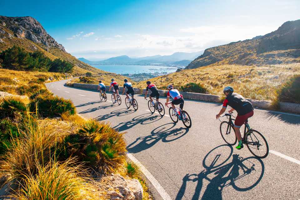 A team of cyclists riding on a hilly road.