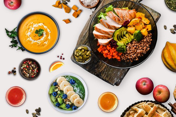A lavish table spread with food items including fruits, baked bread slices, soup and seeds.