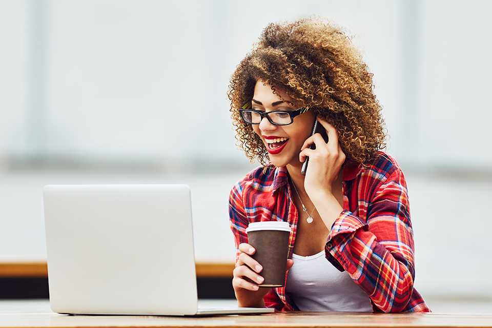 A woman working on her laptop in an outdoor space.