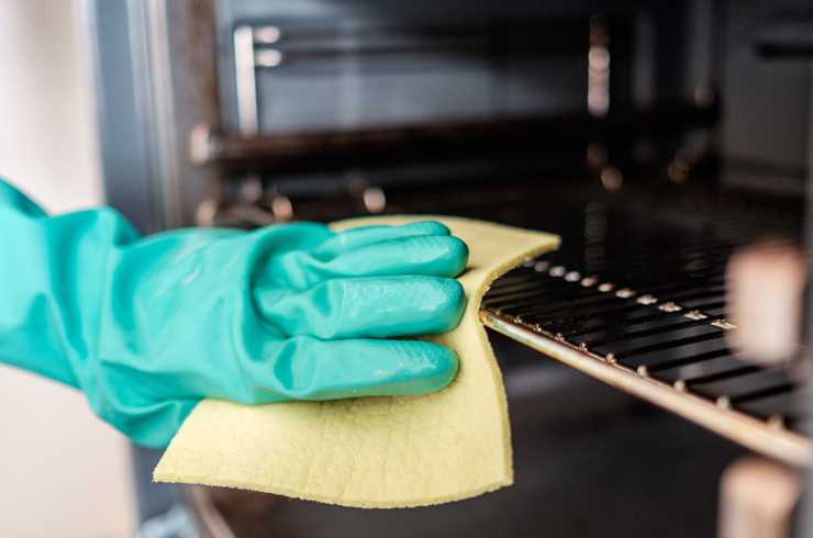 Wiping the oven grills.