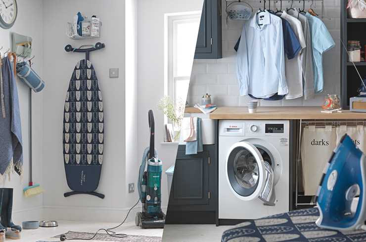 An ironing table, a washing machine, an iron, and clothes hanging on a rail in a utility room.