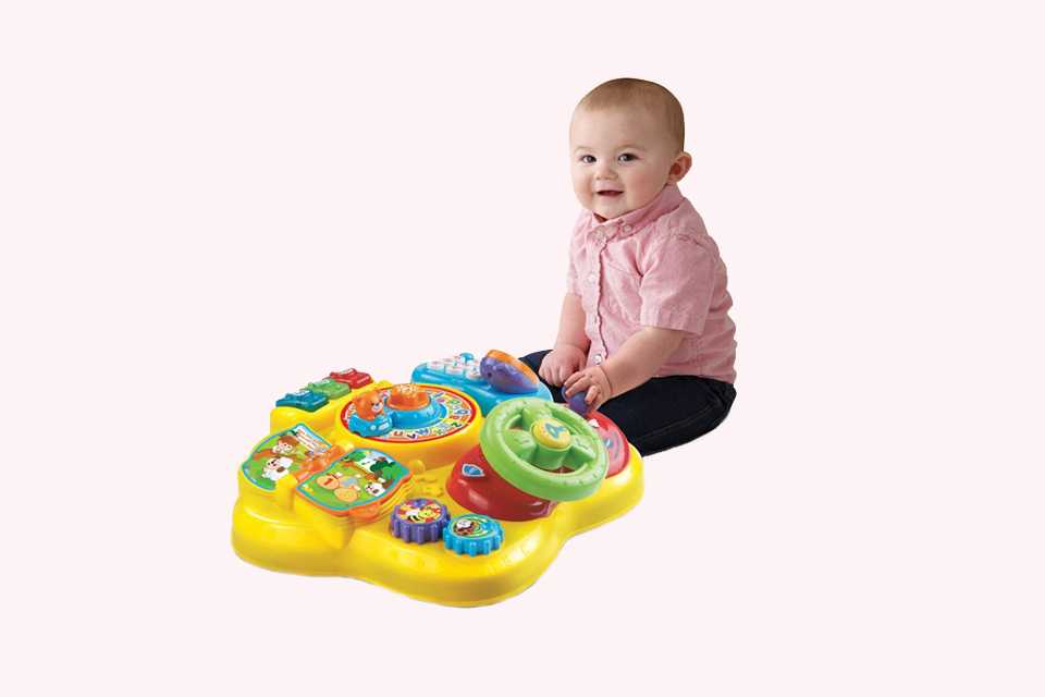 A baby near a VTech little star activity table.
