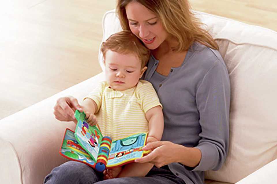 A mom and baby going through an activity book.