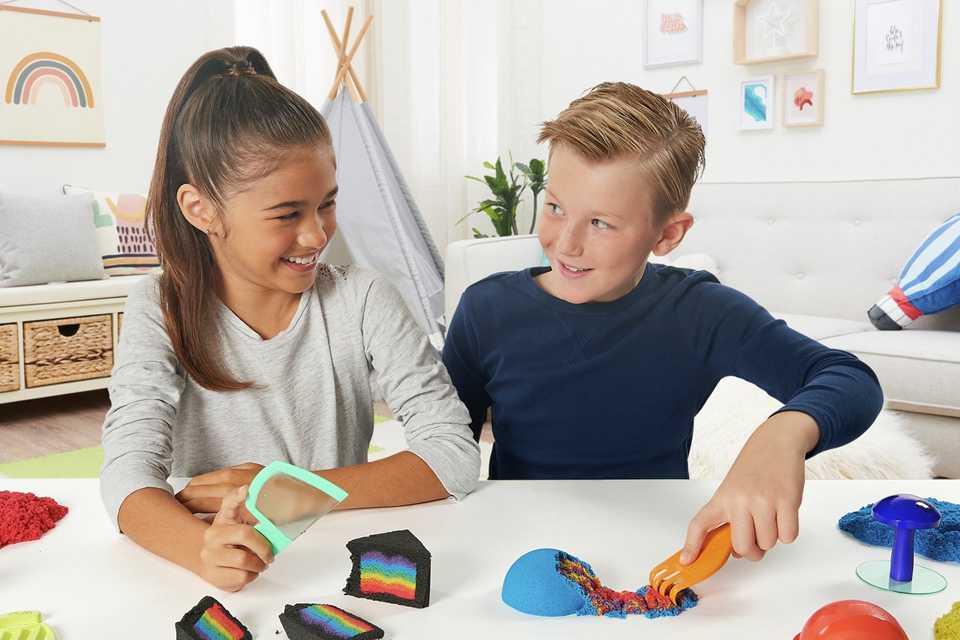 Friends playing with kinetic sand.