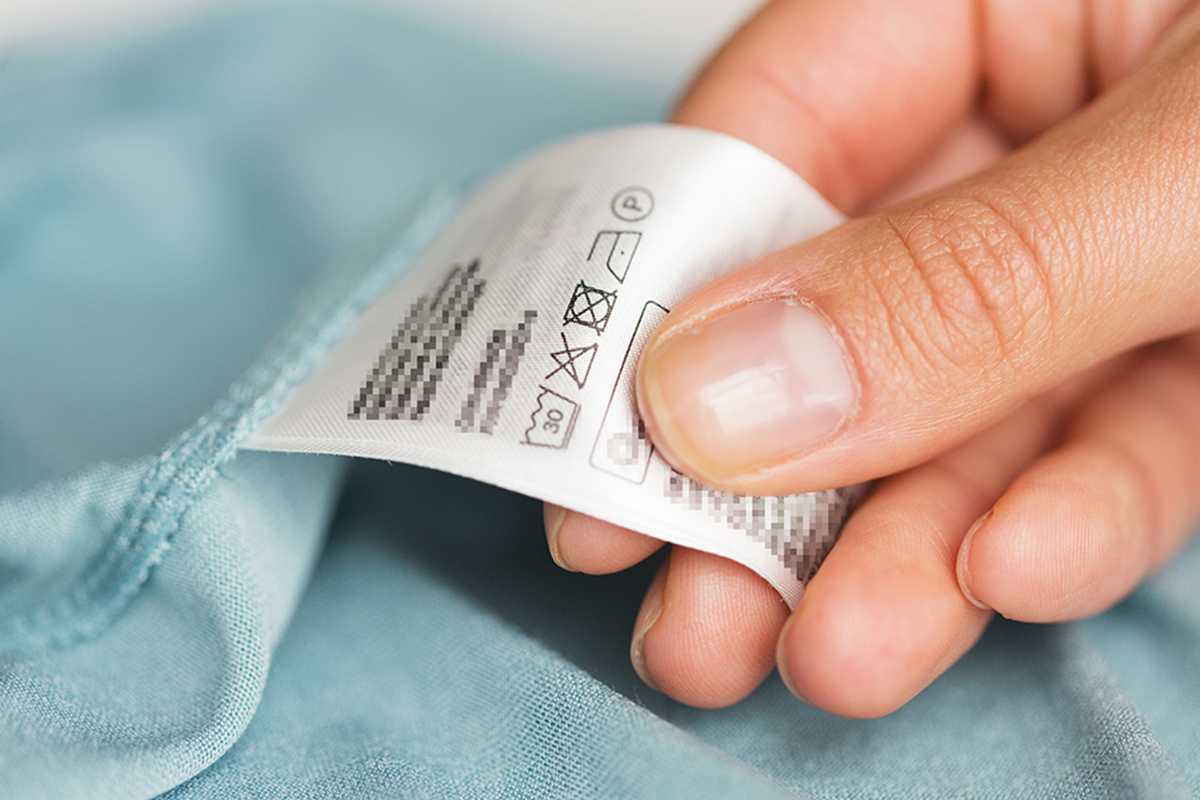 A hand holding a tag on a cloth.