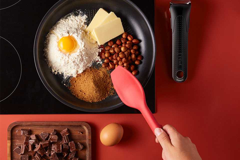 A Tefal Ingenio pan placed on the hob with ingredients in it.