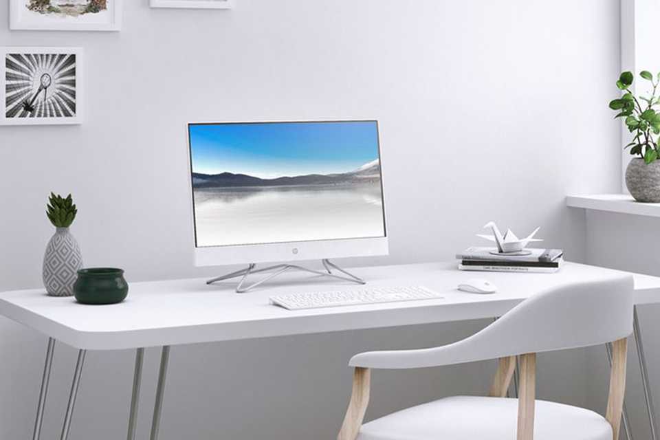 An HP monitor with a keyboard and a mouse placed on a white desk.