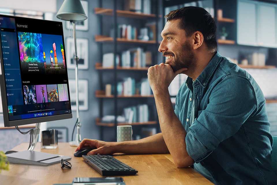 Man smiling using a Lenovo monitor.