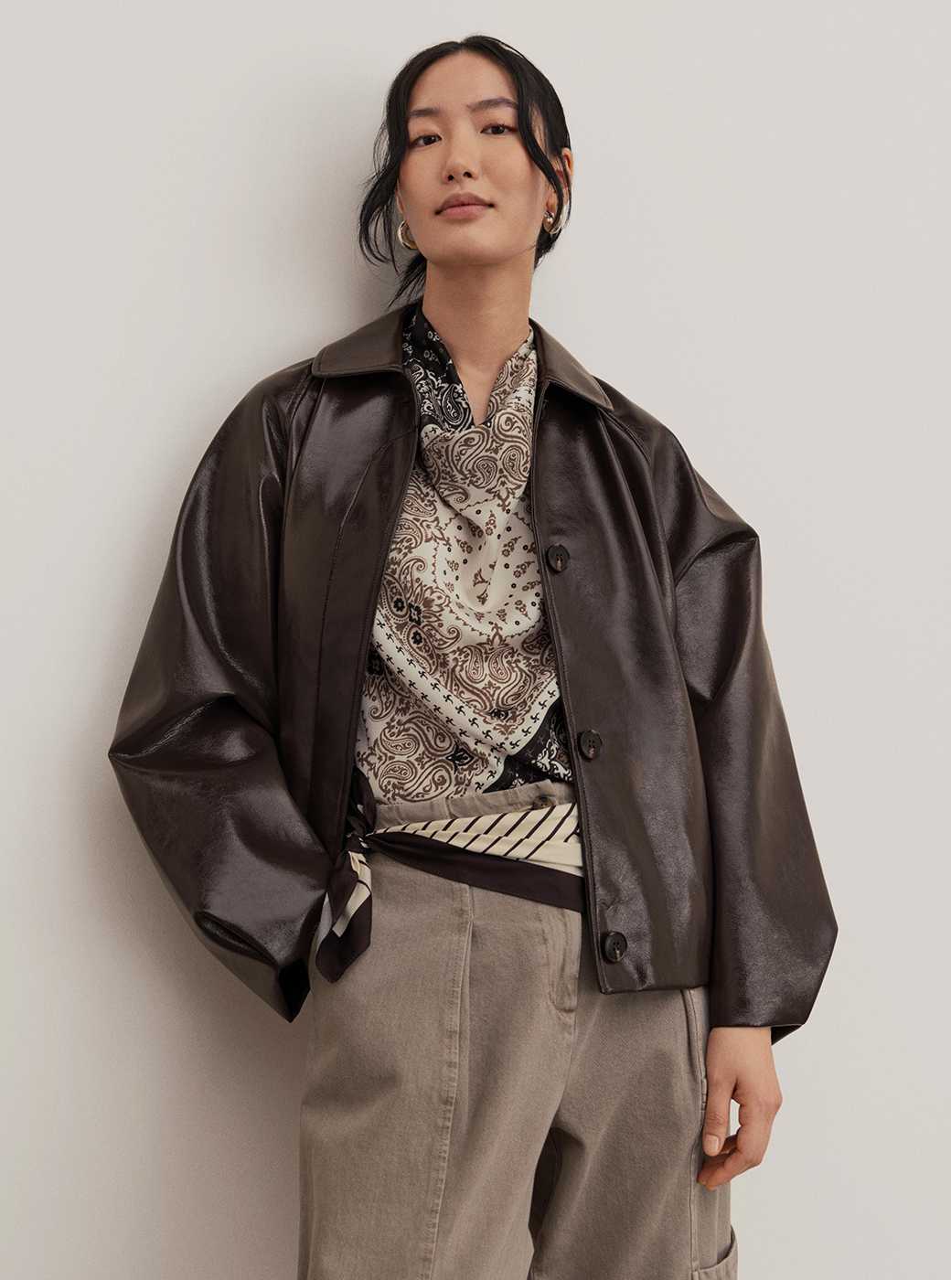 Women wearing dark brown PU jacket with a striped top and jeans.