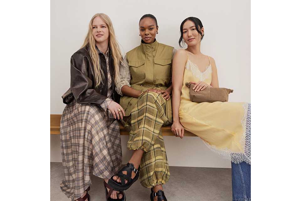 women wearing spring outfits, including a check skirts and brown jacket, middle women is wearing khaki check trousers and khaki gilet jacket, and the women on the right is wearing a lemon slip dress and jeans.