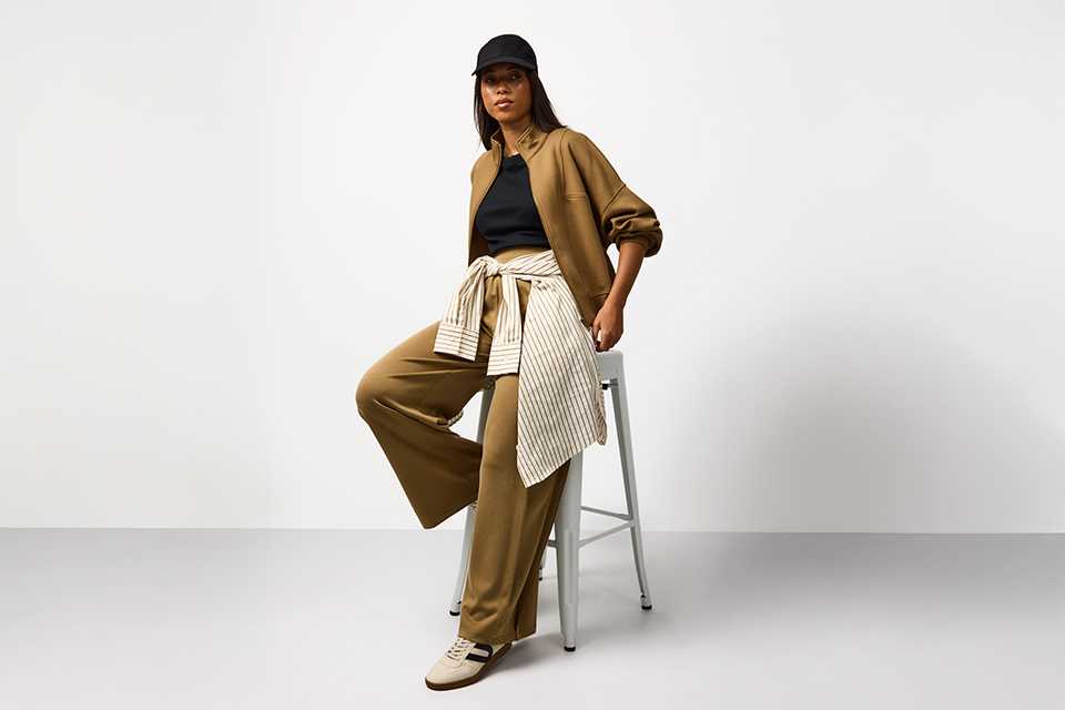 Neutral spring outfit featuring tailored trousers, a soft knit top and lightweight layers, styled for an effortless capsule wardrobe.