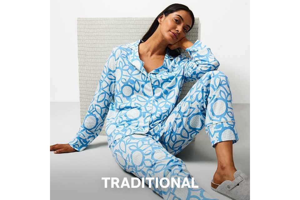 Light-colored button-up pyjama set with small red and blue heart print, styled as traditional nightwear.