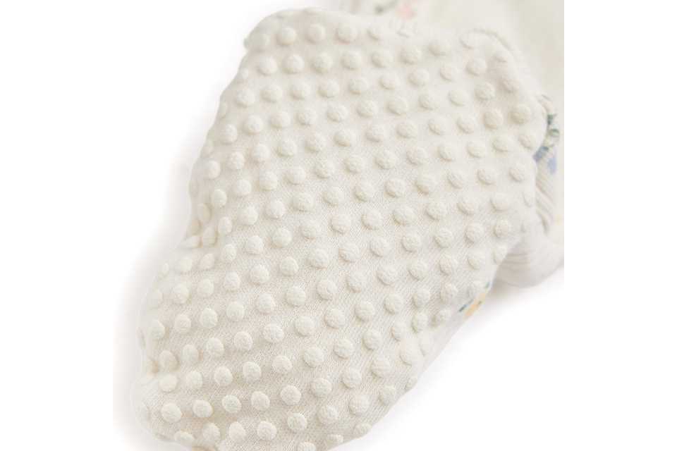 Baby sleepsuit with slip‑resistant dot soles for grip.