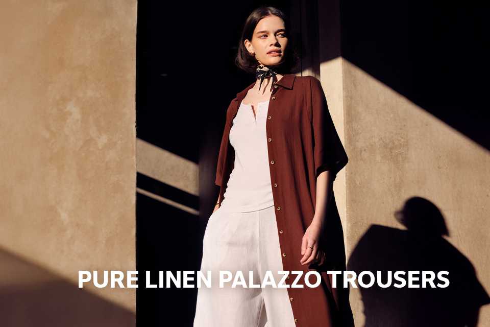 Woman wearing white co-ord with a longline open shirt.