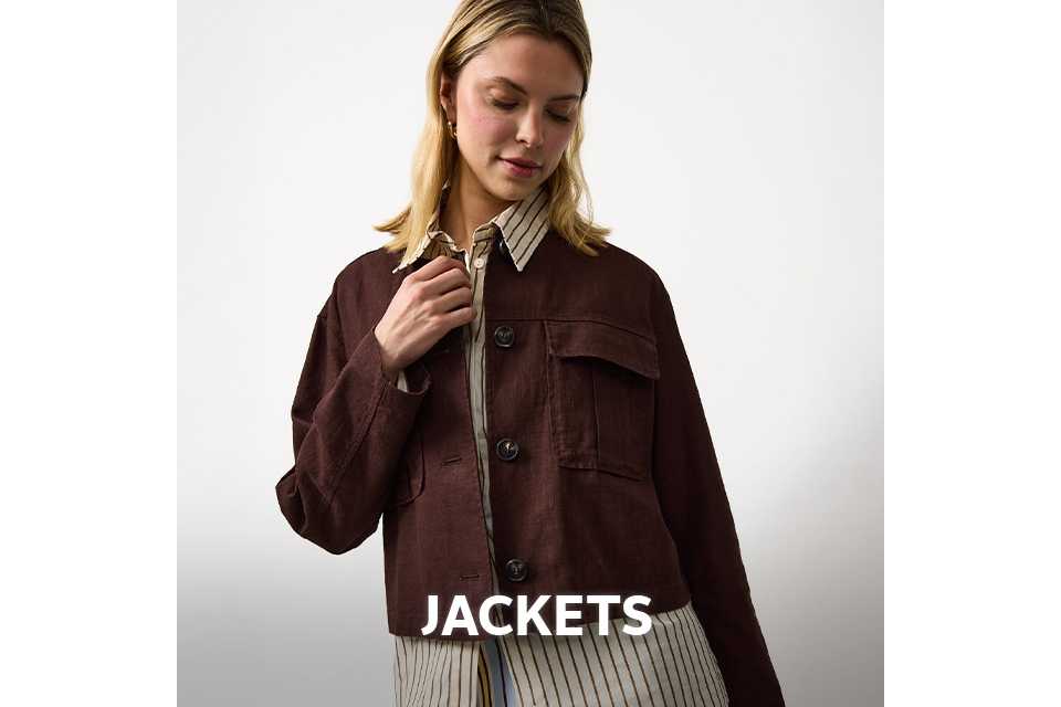 Woman wearing neutral shirt with brown stripes, with a brown cropped jacket.