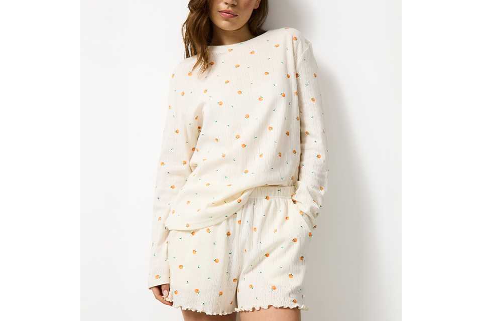 Women’s oversized white nightdress featuring a colourful fruit graphic design, styled in a casual standing pose.