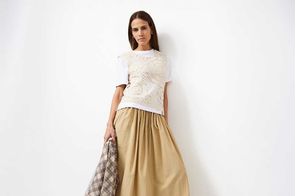 Smart‑casual workwear outfit styled with relaxed top and flowing skirt.